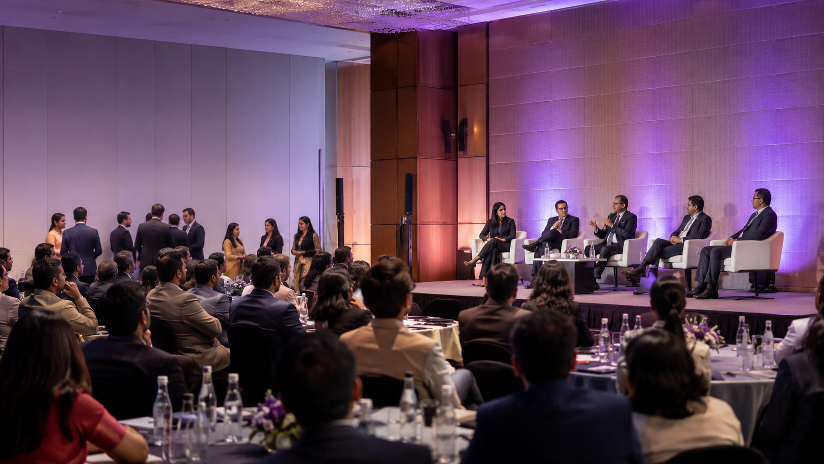 Healthcare leaders and delegates attending a professional conference with subtle purple lighting
